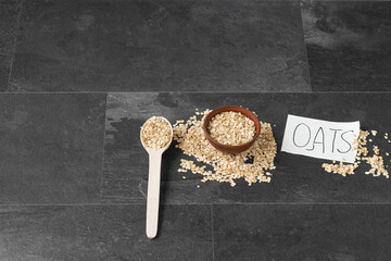 Fototapeta na wymiar Oat flake cereal in wooden bowl with oats word on notebook