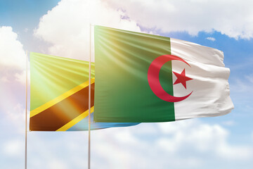 Sunny blue sky and flags of algeria and tanzania