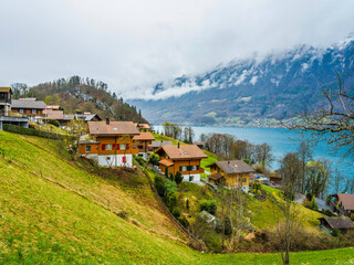 Traditional Swiss houses on hillsside on Lake Brienz in Iseltwald Switzerland