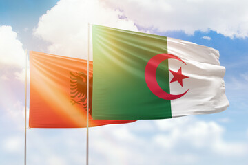 Sunny blue sky and flags of algeria and albania