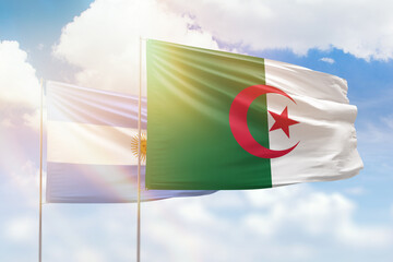 Sunny blue sky and flags of algeria and argentina