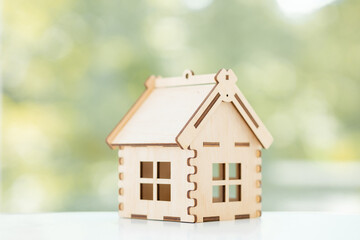 Obraz na płótnie Canvas Mini residential craft house on a green summer background