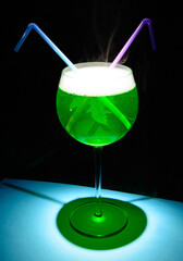 Japanese Slipper cocktail which standing on a blue table. This drink makes your eyebrows raise on first sip. It’s perfectly balanced between sweet and sour, with notes of melon and citrus.