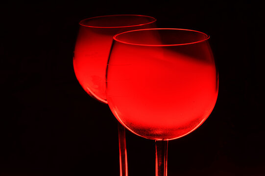 Two Glasses of a Red Alcoholic Cocktail on Dark Background with smoke and backlight. Very dangerous fire cocktail - close up photo. Background picture.