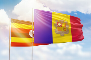 Sunny blue sky and flags of algeria and uganda