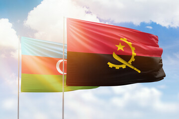 Sunny blue sky and flags of angola and azerbaijan