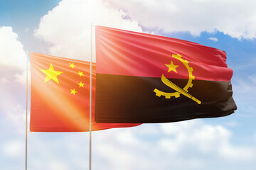 Sunny blue sky and flags of angola and china