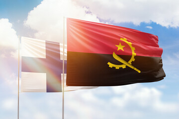 Sunny blue sky and flags of angola and finland