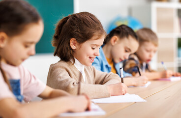 Cheerful girl solving test with classmates