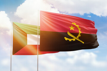 Sunny blue sky and flags of angola and kuwait