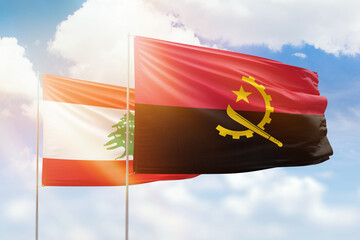 Sunny blue sky and flags of angola and lebanon