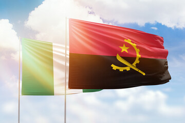 Sunny blue sky and flags of angola and nigeria
