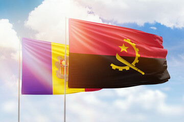 Sunny blue sky and flags of angola and andorra
