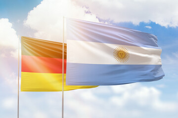 Sunny blue sky and flags of argentina and germany