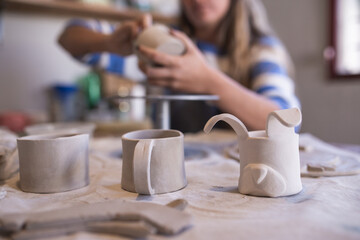 woman making handmade ceramic cups in her workshop