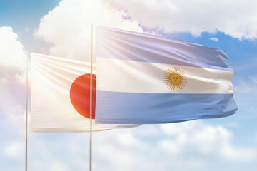 Sunny blue sky and flags of argentina and japan