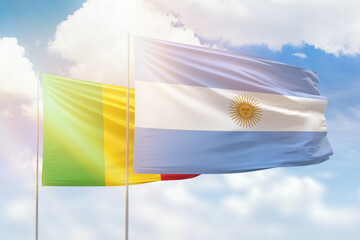 Sunny blue sky and flags of argentina and mali