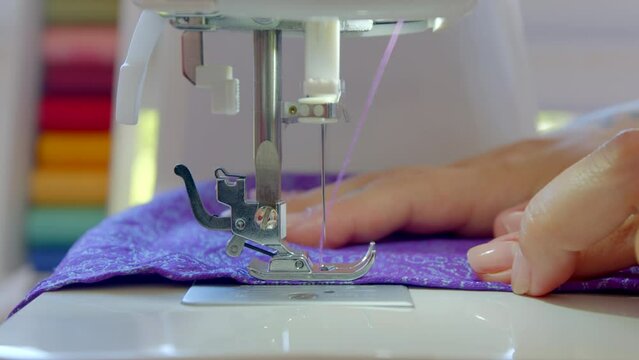 4k colorful close up footage girl woman sews purple lilac clothes. Student tailor designer on summer holidays creating a recycled product. Responsible consumption, handmade creative textile recycling