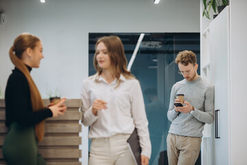 Business people talking while holding coffee cups at office cafeteria