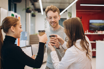 Businessman serving coffee to colleagues in office