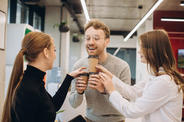 Businessman serving coffee to colleagues in office