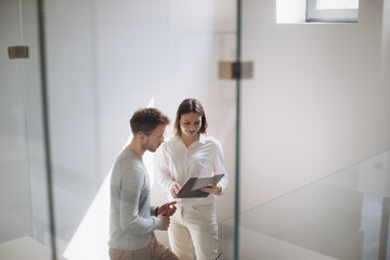 Male and female entrepreneur having discussion while standing in staircase