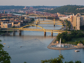 Yellow bridges across the Allegheny River with Point State Park Fountain in Pittsburgh, Pennsylvania (PA), USA.