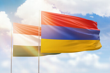 Sunny blue sky and flags of armenia and hungary