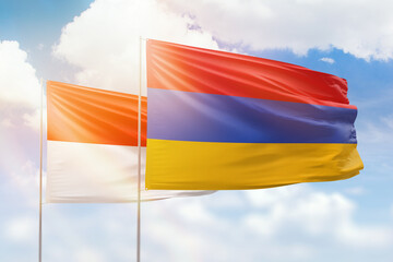Sunny blue sky and flags of armenia and indonesia