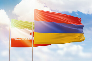Sunny blue sky and flags of armenia and iran