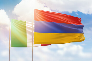 Sunny blue sky and flags of armenia and italy