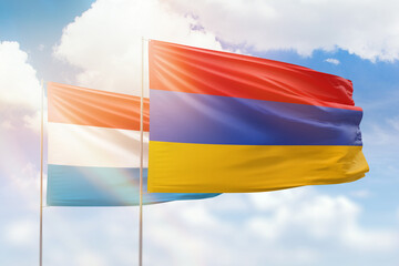 Sunny blue sky and flags of armenia and luxembourg