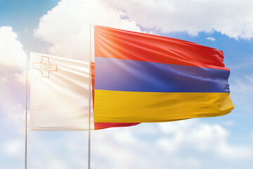 Sunny blue sky and flags of armenia and malta