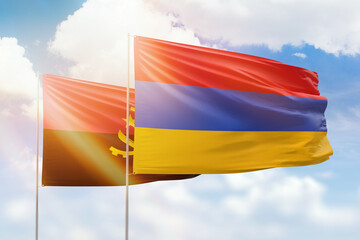 Sunny blue sky and flags of armenia and angola