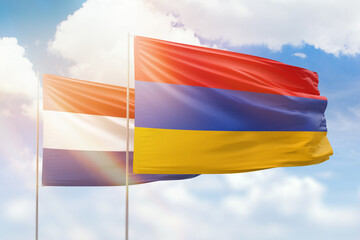 Sunny blue sky and flags of armenia and netherlands