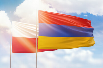 Sunny blue sky and flags of armenia and poland