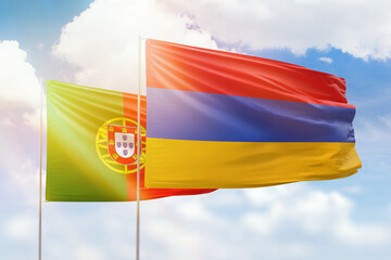 Sunny blue sky and flags of armenia and portugal