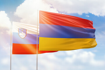 Sunny blue sky and flags of armenia and slovenia