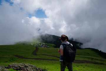 Obraz premium Rize, Turkey - July 2016: A tourist watching the sea of clouds on the high plateau. Photo was taken in plateau in Rize, Karadeniz region of Turkey. 