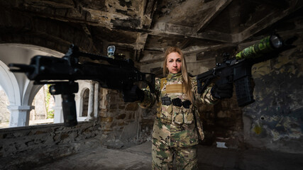 Fototapeta premium Caucasian woman in army uniform holding two machine guns. 