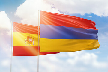Sunny blue sky and flags of armenia and spain