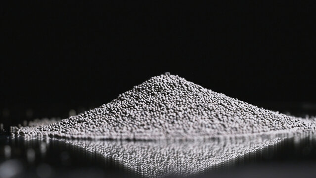 Pile of stones isolated over black background. Stock footage. Close up of small rubble falling down to the pile placed on glass reflectie surface.
