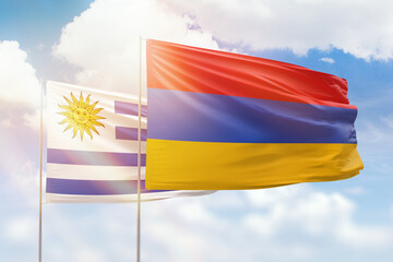 Sunny blue sky and flags of armenia and uruguay