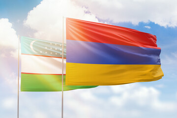 Sunny blue sky and flags of armenia and uzbekistan