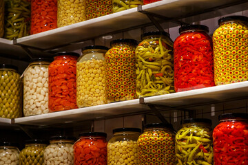 Pickled vegetables in jars on the shelf in the pantry.