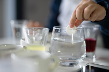 Close up on hand of One small caucasian boy scientist five years old sitting at the table playing with chemistry equipment toy preforming experiment learning and education concept front view