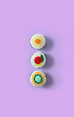Delicious and fresh traditional Japanese sushi roll set handmade in crochet and colored wool. Top view. Sushi rolls isolated on a purple background vertical. Sushi crochet amigurumi