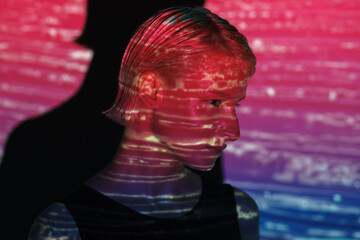 fashion androgyne woman with projection of neon pink stripe on face