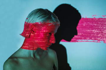 fashion androgyne woman with projection of neon pink stripe on face