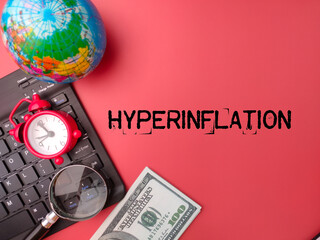 Top view clock,magnifying glass,earth globe and banknotes with the word HYPERINFLATION.
